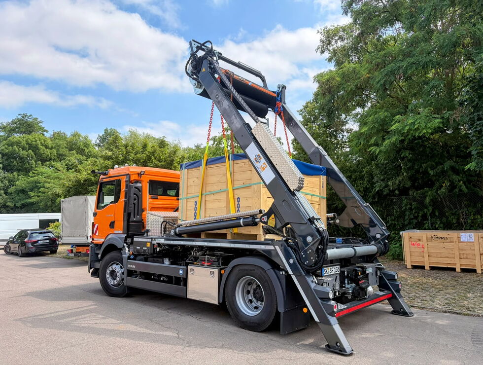 Orange truck with a built-in conveyor belt for installing UV-curing fiberglass liners.