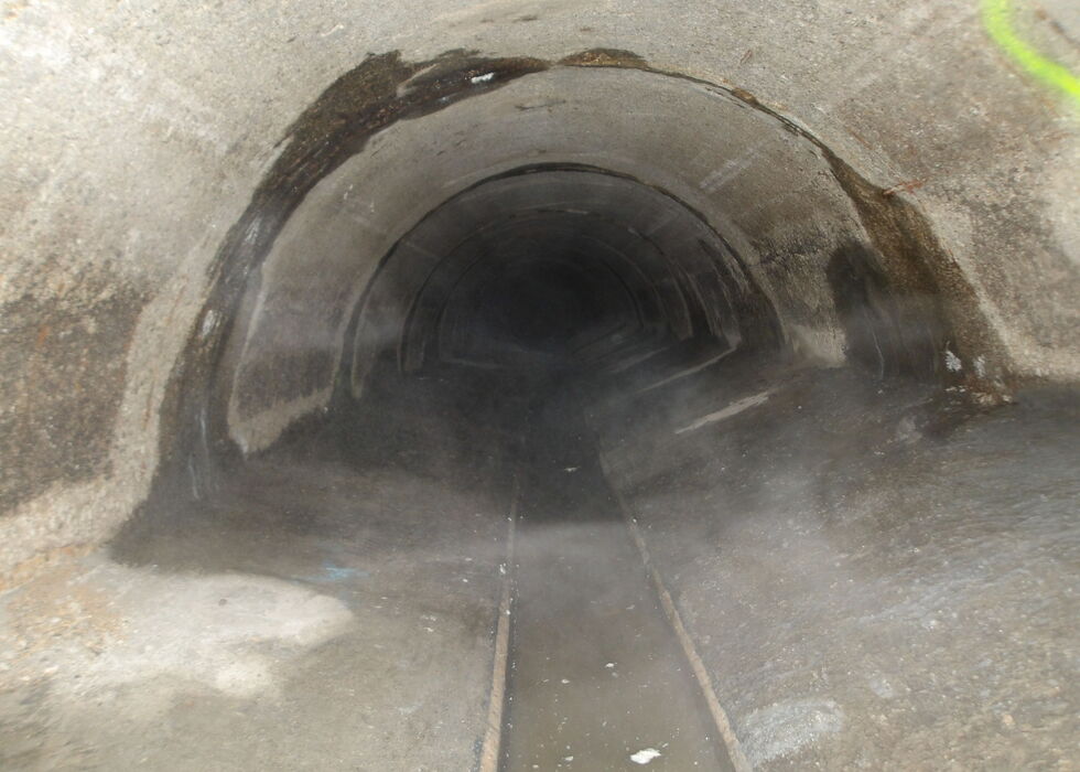 Dunkles Tunnelinnere mit einem schmalen Gleis in der Mitte.