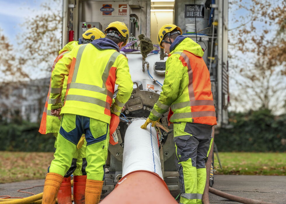 Ein Rettungsteam in Warnschutzkleidung richtet eine Trage neben der Straße ein.