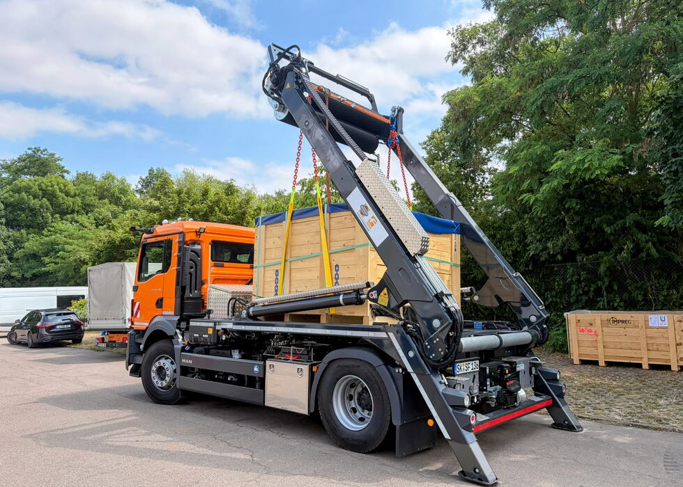 Orangefarbener Lkw mit integriertem Förderband für den Einbau UV-härtender Glasfaserliner.