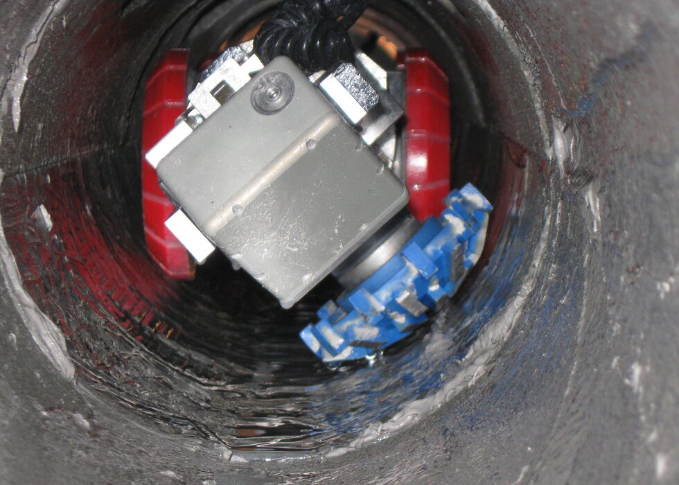 Ein Roboter mit Rädern in einem zylindrischen Rohr, von oben gesehen.