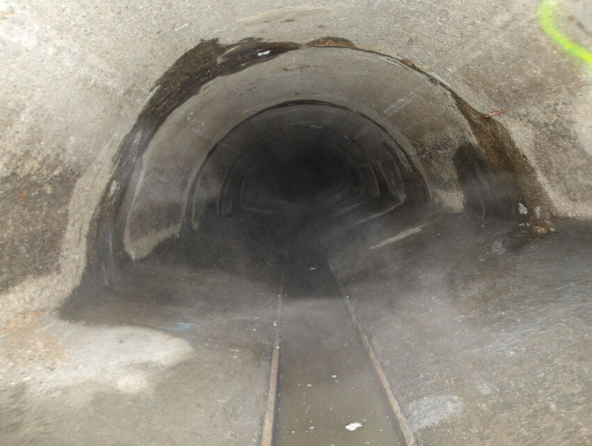 Dunkles Tunnelinnere mit einem schmalen Gleis in der Mitte.