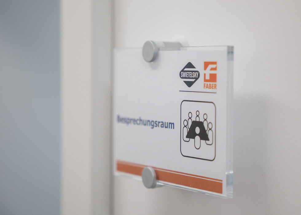 Türschild, das einen Besprechungsraum im Büroflur kennzeichnet.