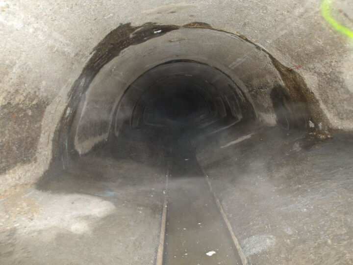 Dunkles Tunnelinnere mit einem schmalen Gleis in der Mitte.