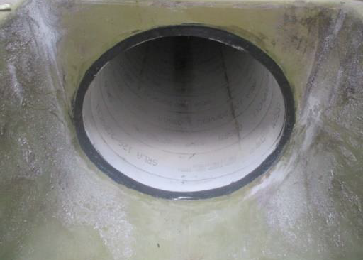Runde Betonrohröffnung in einer rauen Wandoberfläche.