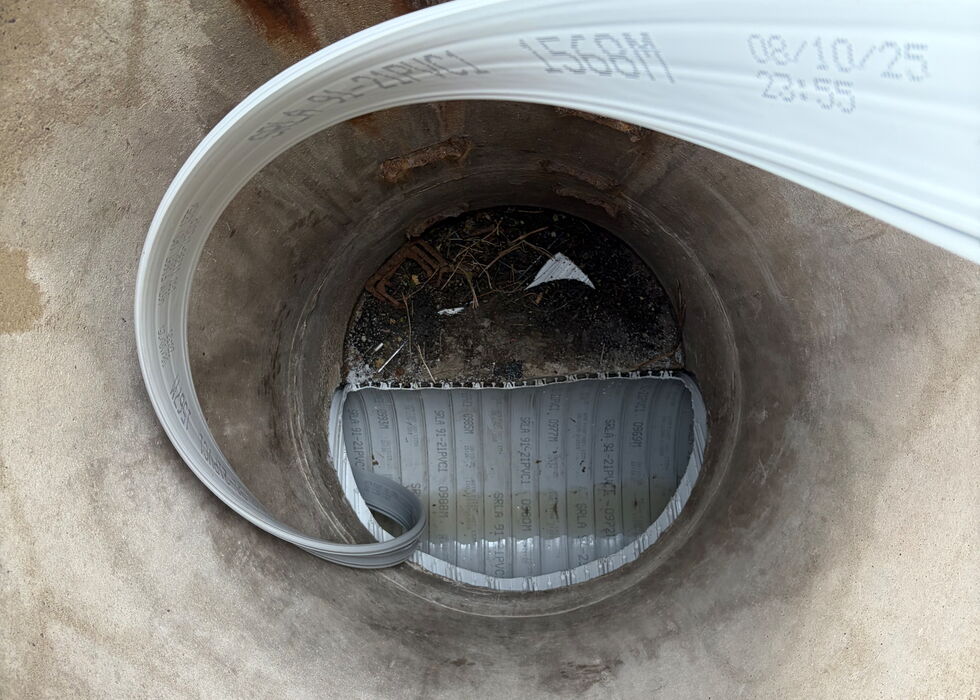 A spiral pipe profile is inserted into the sewer through the manhole.