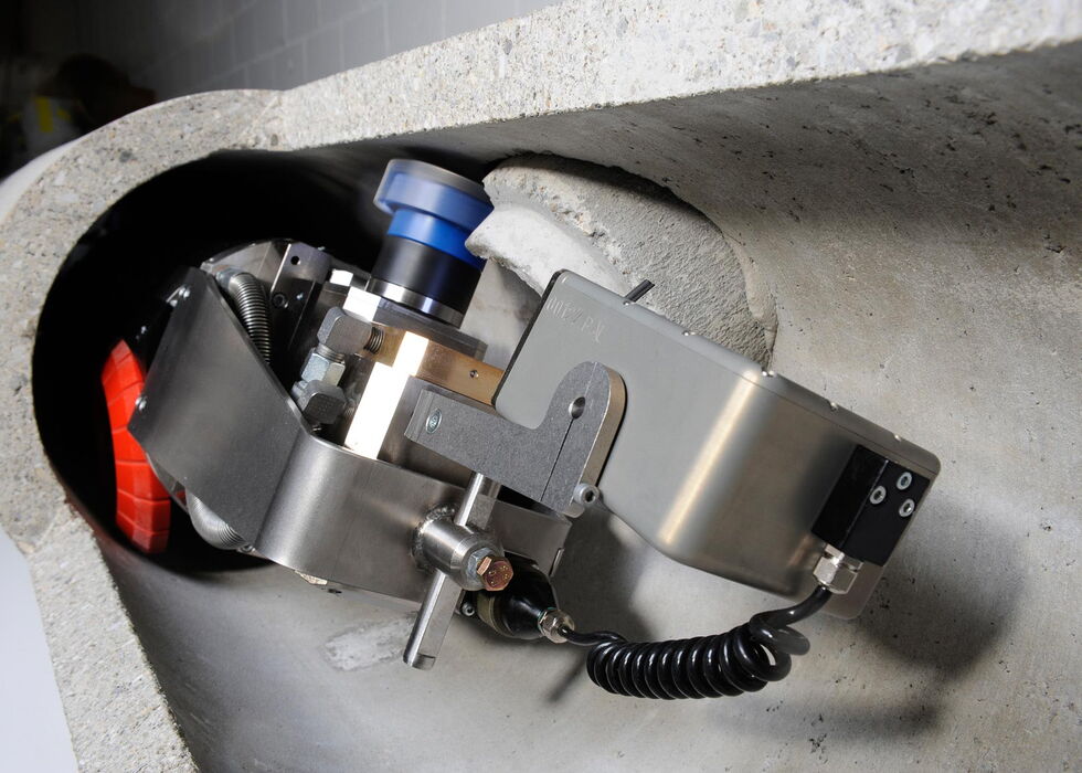 Ein Roboter zur Inspektion, der in einer Betonrohr- oder Tunnelöffnung montiert ist.